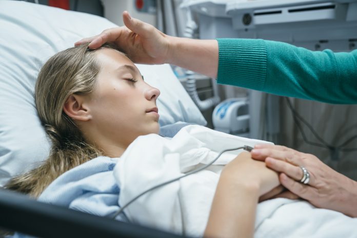 Mom-touching-forehead-of-teen-patient-in-hospital-Inti-StClair-fn201707155151
