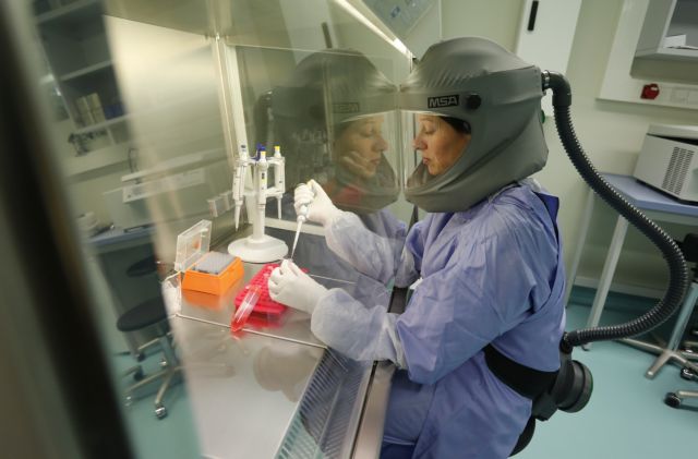 Dr. Muth from the virology institute of the Bonn Faculty of Medicine works under a flow head at a clean bench in a biosafety level three (BSL-3) laboratory in the western German city of Bonn
